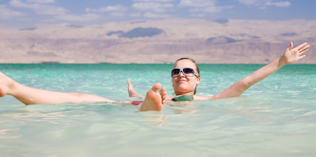 Beauty Woman Lying On Water. Dead Sea. Israel