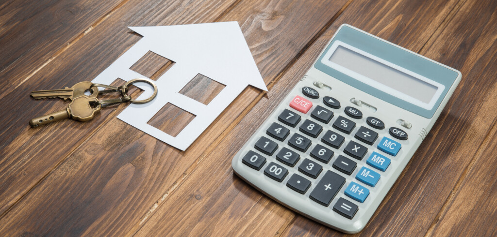 house and key with Calculator on wooden background