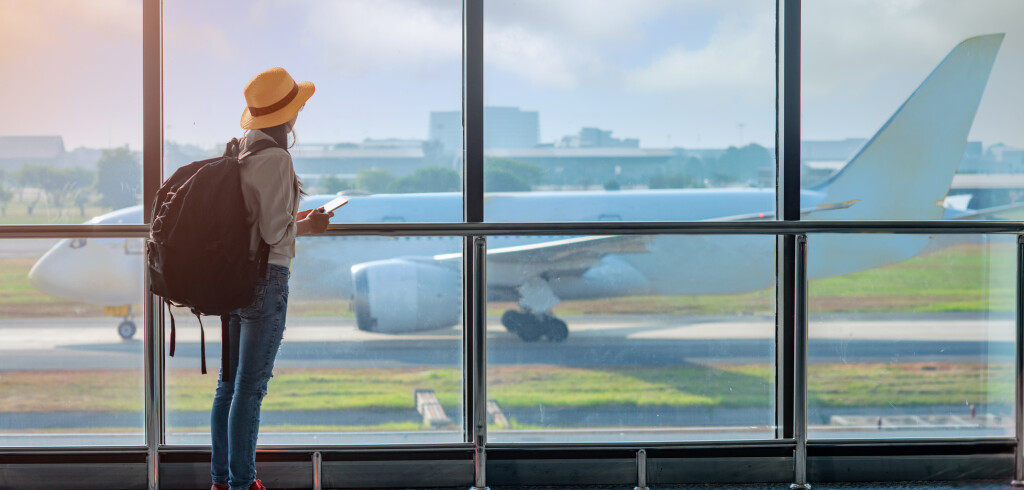 woman passenger tourist or traveller in late, delay checking in the gate terminal at boarding pass entrance, aircraft just leaving from the terminal