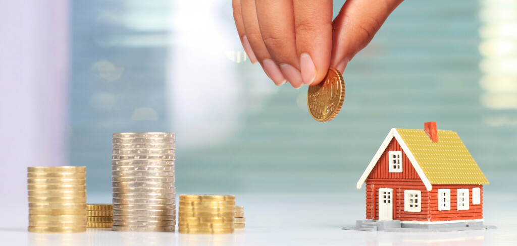 Real estate investment. House and coins on table.