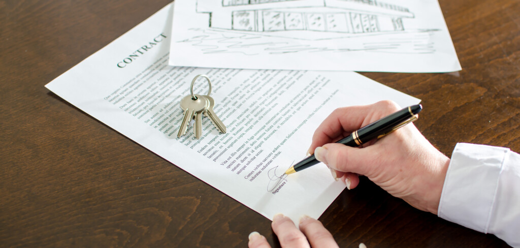 Woman signing a real estate contract on a desk