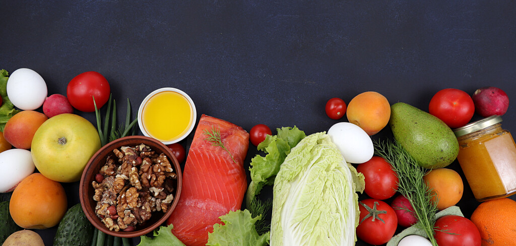Vegetables, fruits and red fish on a dark background. The concept of healthy and natural food for weight loss, lifestyle, detox diet, keto diet, the purpose of which is to exclude carbohydrates,