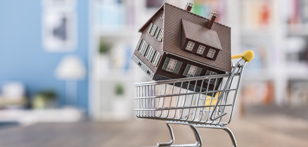 Model house in a miniature shopping cart: real estate, investments and home buying