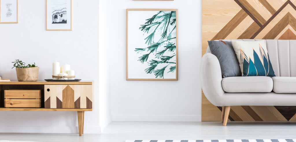 Gallery of posters in rustic living room interior with beige sofa near wooden cupboard with candles