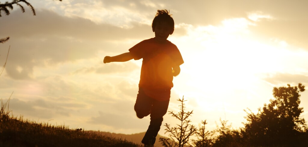 Kid running on meadow silhouette